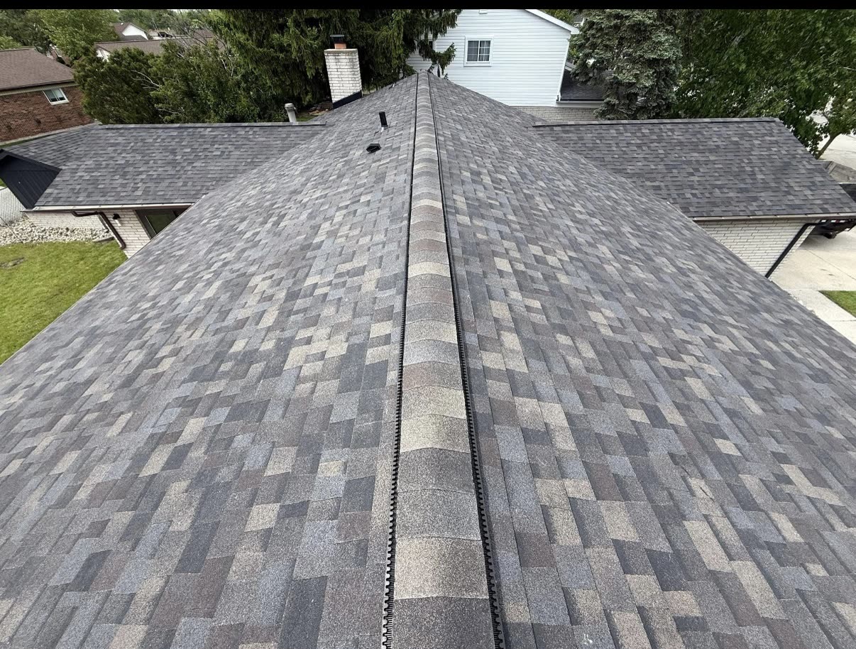 BrightView Construction crew finishing the shingles on a large multicolor roof with dormers
